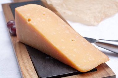 Sert olgunlaşmış 3 yıllık koyu sarı peynir. Yaklaş.