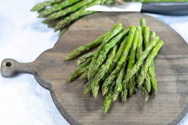 Tahtada taze çiğ yeşil kuşkonmaz sebzesi. Yakın plan.