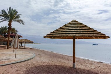 Eilat 'taki Kızıl Deniz' de güzel halk kumlu plajlar. Şemsiyeli, İsrail 'deki lüks tatil merkezleri.
