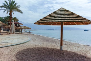 Eilat 'taki Kızıl Deniz' de güzel halk kumlu plajlar. Şemsiyeli, İsrail 'deki lüks tatil merkezleri.