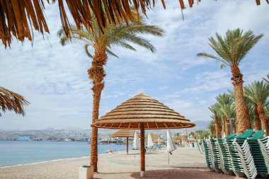 Eilat 'taki Kızıl Deniz' de güzel halk kumlu plajlar. Şemsiyeli, İsrail 'deki lüks tatil merkezleri.