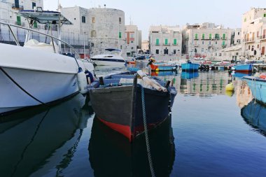 Sabahın erken saatlerinde Bari, Apulia, İtalya yakınlarındaki eski küçük şehir Giovinazzo 'da renkli ahşap tekneleri olan eski balıkçı limanı.