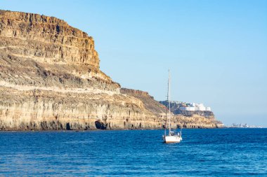Kış güneşi istikameti, Puerto Mogan, Gran Canaria, Kanarya Adaları, İspanya yakınlarındaki kayalıklı okyanus kıyıları.