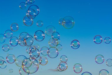 Arka planda bir sürü sabun köpüğü, mavi gökyüzü, herkes için açık hava eğlencesi