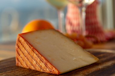 Kırmızı biber kaplı İspanyol keçi sütü peyniri ve olgun pembe üzümler yakın.