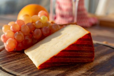 Kırmızı biber kaplı İspanyol keçi sütü peyniri ve olgun pembe üzümler yakın.