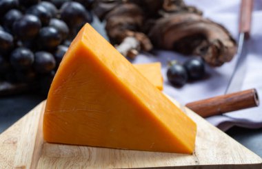 Siyah üzümle servis edilen sert portakallı çedar peyniri.