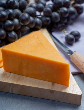 Siyah üzümle servis edilen sert portakallı çedar peyniri.