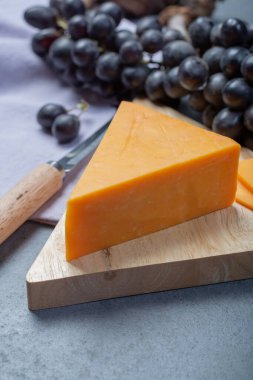 Siyah üzümle servis edilen sert portakallı çedar peyniri.