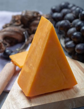 Siyah üzümle servis edilen sert portakallı çedar peyniri.