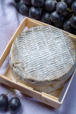 Olgun Fransız Tomme peyniri siyah üzümle servis edilir.