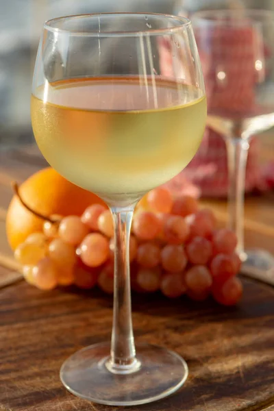 stock image Aperitif cold white wine served in glasses with pink grapes on outdoor tessace witn sea view close up