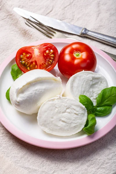 柔らかい白いイタリアチーズ新鮮なトマトと緑のバジルの葉を添えたモッツァレラバッファロー白い背景 — ストック写真