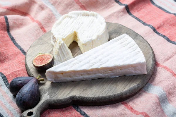 2枚のフランスのソフトチーズBrieとCamembertに白いカビと強い匂いがあり 新鮮な熟したイチジクが閉じられています — ストック写真