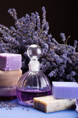 Doğal sağlıklı aromaterapi ve organik Fransız lavantası, lavanta sabunu, vücut kremi ve mor arka planda kurutulmuş lavanta çiçekleriyle cilt tedavisi.