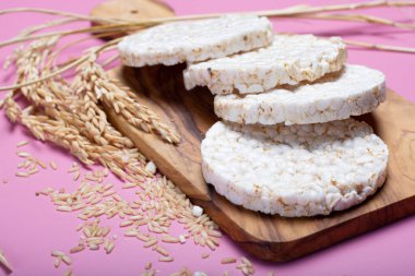 Yuvarlak çıtır pirinç krakerleri, beslenme konsepti ve modaya uygun pembe arka planda sağlıklı vejetaryen yemekleri.