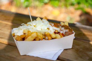 Dışarıda taze kızarmış Belçika patatesleri, ketçap ve sosla servis ediliyor.