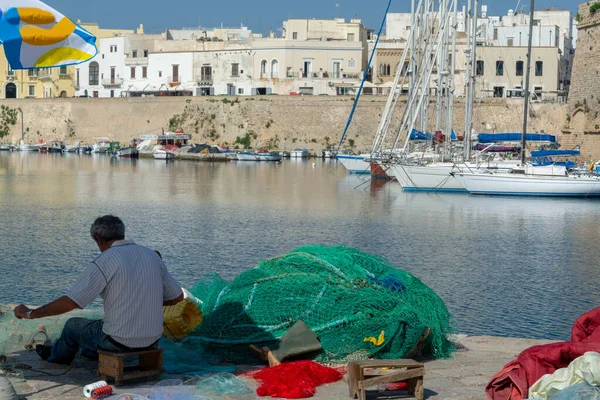 Morning landscape photo made in Gallipoli pier, fishermen reparing his fishermen net after fishing, Apulia, Italy — Stock Image Morning Landscape Photo Made Gallipoli Pier Fishermen Reparing His Fishermen Stock Photo