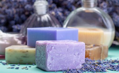 Doğal sağlıklı aromaterapi ve organik Fransız lavantası, lavanta sabunu ve yeşil arka planda kurutulmuş lavanta çiçekleriyle cilt tedavisi.