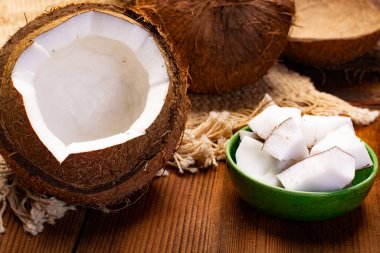 Büyük tropikal fındık cevizi ve hindistan cevizi parçaları ahşap zemin üzerinde yemeye hazır.