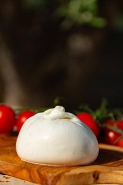 Taze beyaz burrata, tereyağlı peynir, mozzarella ve krema karışımı, Apulia bölgesinden orijinal, domatesli.
