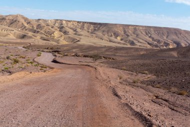 İsrail, Negev çölündeki toprak yol, çöldeki altyapı taşımacılığı, Eilat 'tan İsrail' in kuzeyine giden manzaralı dağlar.