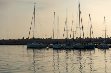 Sabahın erken saatlerinde Bari, Apulia, İtalya yakınlarındaki eski küçük şehir Giovinazzo 'da renkli ahşap tekneleri olan eski balıkçı limanı.