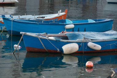 Sabahın erken saatlerinde Bari, Apulia, İtalya yakınlarındaki eski küçük şehir Giovinazzo 'da renkli ahşap tekneleri olan eski balıkçı limanı.