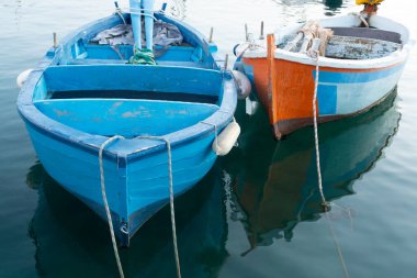 Sabahın erken saatlerinde Bari, Apulia, İtalya yakınlarındaki eski küçük şehir Giovinazzo 'da renkli ahşap tekneleri olan eski balıkçı limanı.