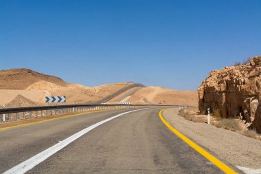 Çölde asfalt yol Negev, İsrail, yol 40, çölde altyapı taşıma, Eilat 'tan İsrail' in kuzeyine giden manzaralı dağlar.
