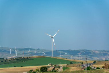 Büyük rüzgar türbinleri kuleleri olan modern rüzgar çiftliği yenilenebilir yeşil enerji kaynağı