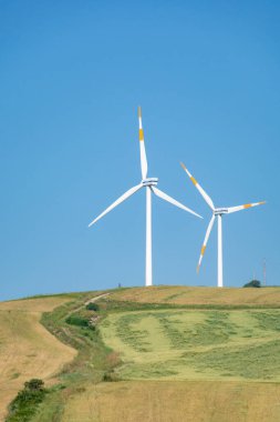 Büyük rüzgar türbinleri kuleleri olan modern rüzgar çiftliği yenilenebilir yeşil enerji kaynağı