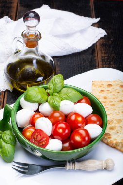 İtalyan yumuşak peyniri, taze küçük toplar mozzeralla peynirli salata taze fesleğen, lezzetli vişneli domates ve İtalyan zeytinyağı ile servis edilir.