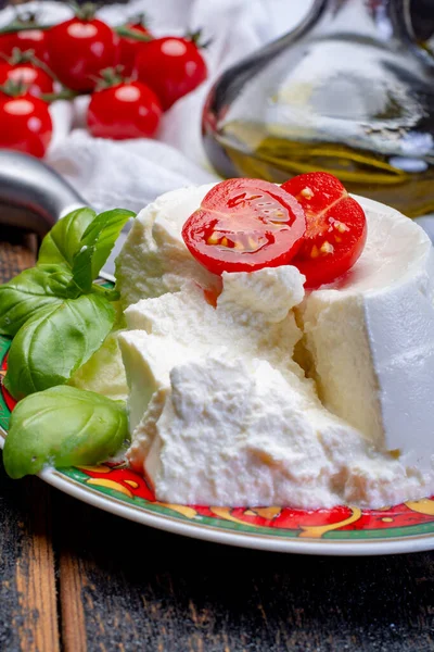 Italian soft cheese, young white ricotta cheese served with fresh basil and tasty ripe cherry tomatoes