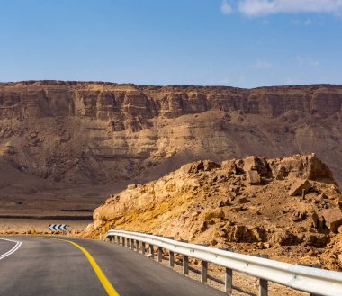 Çölde asfalt yol Negev, İsrail, yol 40, çölde ulaşım altyapısı, İsrail 'de Mizpe Ramon kanyonu manzaralı dağlar.