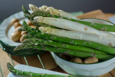 Çiğ beyaz ve yeşil kuşkonmaz ve küçük patatesler, akşam yemeği için hazır.