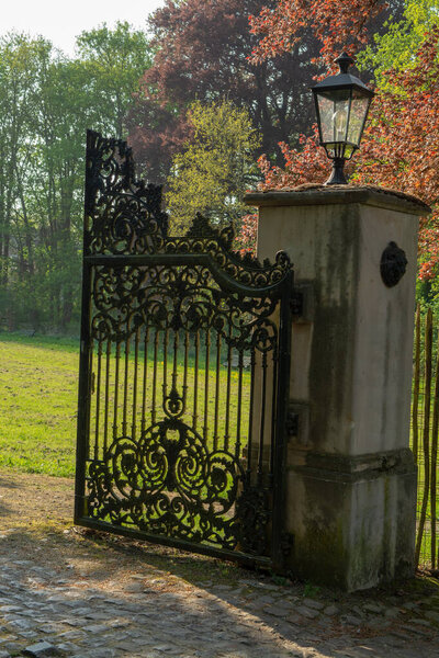 Open iron vintage entrance gates in old castle, sunny day