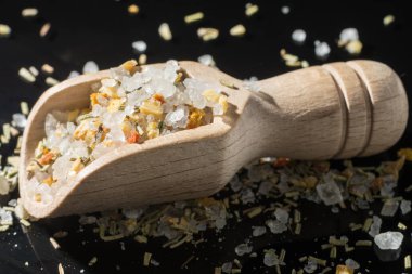 Makro koleksiyonu, İtalyan otlarıyla karıştırılmış beyaz deniz tuzu, biberiye ve siyah arka planda baharatlar.