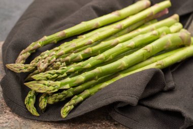 Bir avuç pişmemiş yeşil kuşkonmaz, lezzetli vejetaryen yemeği.