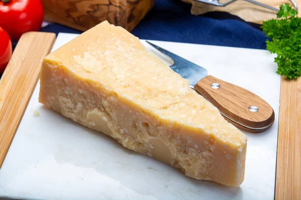 奶酪系列 一块意大利产的古老的帕尔梅奶酪 装在白色大理石板上 — 图库照片