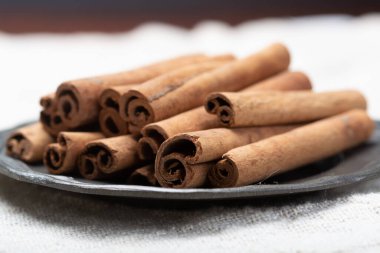 Kışın yemek malzemesi, kurutulmuş aromatik tarçın çubukları teneke tabakta yakın.