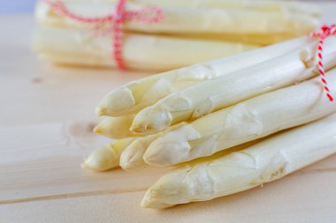 Yeni beyaz kuşkonmaz hasadı, bahar mevsiminde iki demet yüksek kaliteli çiğ kuşkonmaz, yakın pişirmeye hazır.