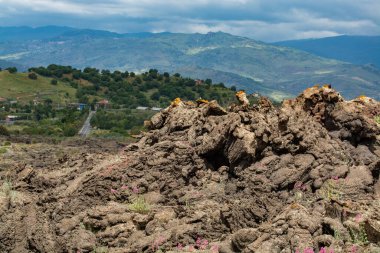 İlkbaharda İtalya 'nın Sicilya adasındaki Etna Ulusal Parkı' ndaki Etna Dağı 'nın yamaçlarındaki yeni püskürme lav sahalarından sadece birkaç metre uzaklıktaki küçük köye bakın.