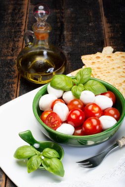 İtalyan yumuşak peyniri, taze küçük toplar mozzeralla peynirli salata taze fesleğen, lezzetli vişneli domates ve İtalyan zeytinyağı ile servis edilir.