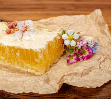 Ev yapımı organik bal peteğinde dağ çayırlarındaki kovanlardan yaz çiçekleri eşliğinde.