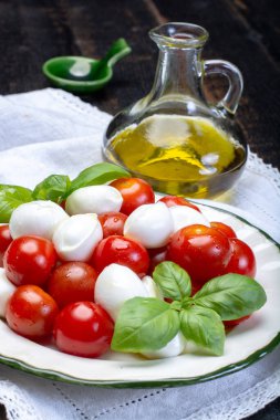 İtalyan yumuşak peyniri, taze küçük toplar mozzeralla peynirli salata taze fesleğen, lezzetli vişneli domates ve İtalyan zeytinyağı ile servis edilir.