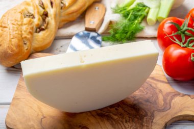 İtalyan peyniri, Cremona 'dan gelen Provolone Dolce inek peyniri zeytin ekmeği ve domatesle servis ediliyor.