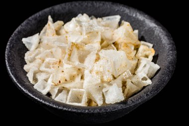 Makro koleksiyonu, beyaz deniz tuzu piramit taneleri ve siyah arka planda baharatlar.