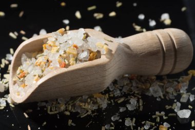 Makro koleksiyonu, İtalyan otlarıyla karıştırılmış beyaz deniz tuzu, biberiye ve siyah arka planda baharatlar.