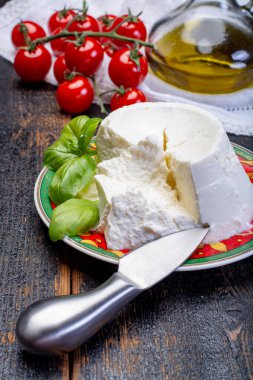 İtalyan yumuşak peyniri, taze beyaz ricotta peyniri taze fesleğen ve taze vişneli domatesle servis edilir.